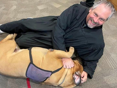 A man sits on a floor with a dog