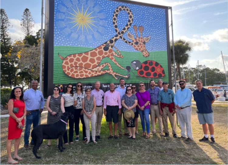 This is an image of a group of people standing in front of artwork.